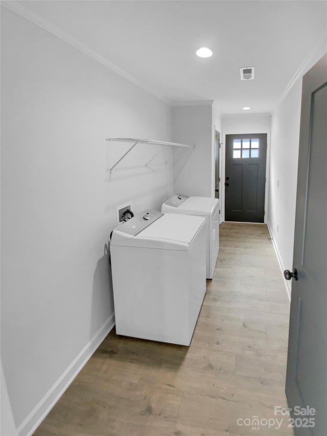 washroom with visible vents, independent washer and dryer, light wood-style flooring, baseboards, and laundry area