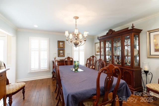 dining area featuring an inviting chandelier, a healthy amount of sunlight, and ornamental molding