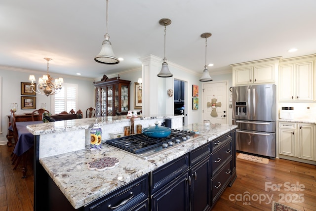 kitchen with a kitchen island, cream cabinetry, stainless steel appliances, and dark wood-style flooring