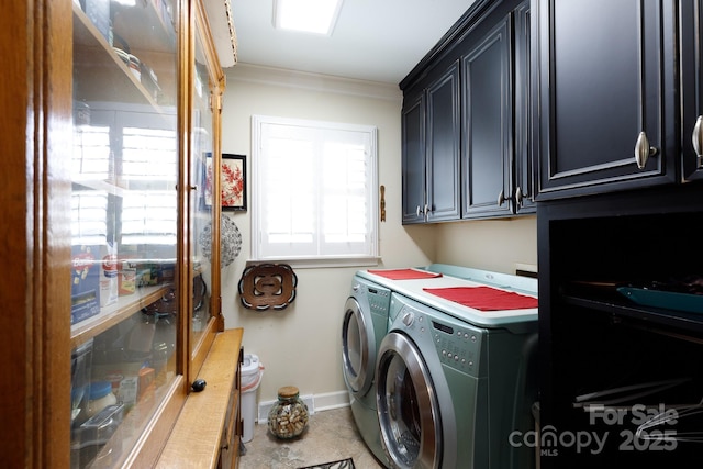 clothes washing area with washing machine and clothes dryer, cabinet space, crown molding, and baseboards