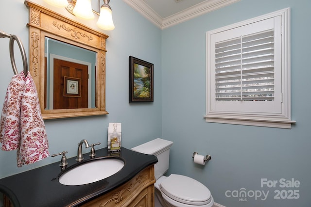 half bath featuring toilet, vanity, and ornamental molding