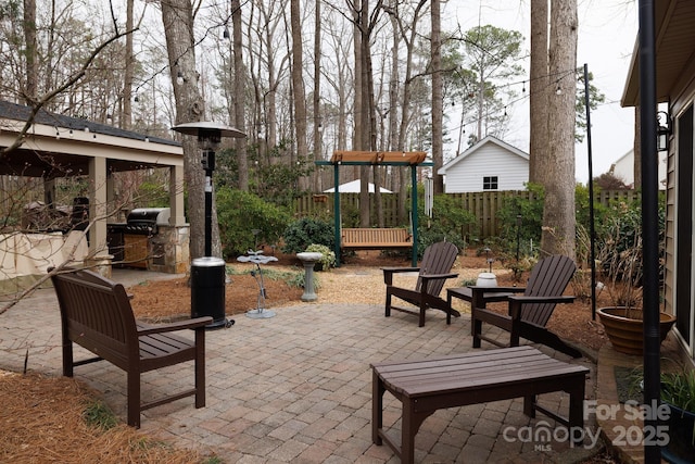 view of patio featuring area for grilling, an outdoor kitchen, and fence