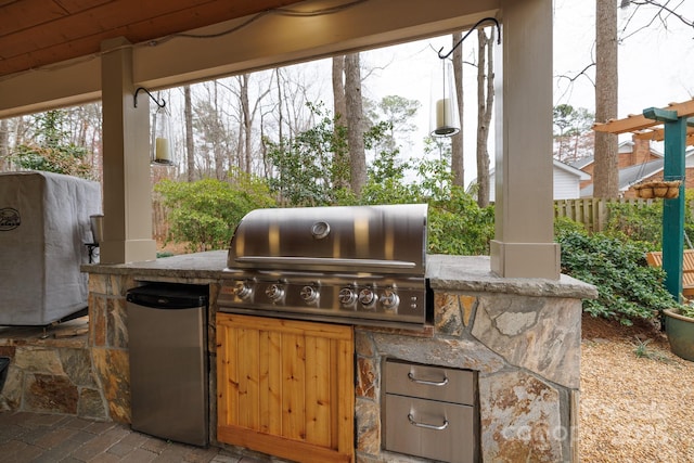 view of patio with grilling area, exterior kitchen, and fence