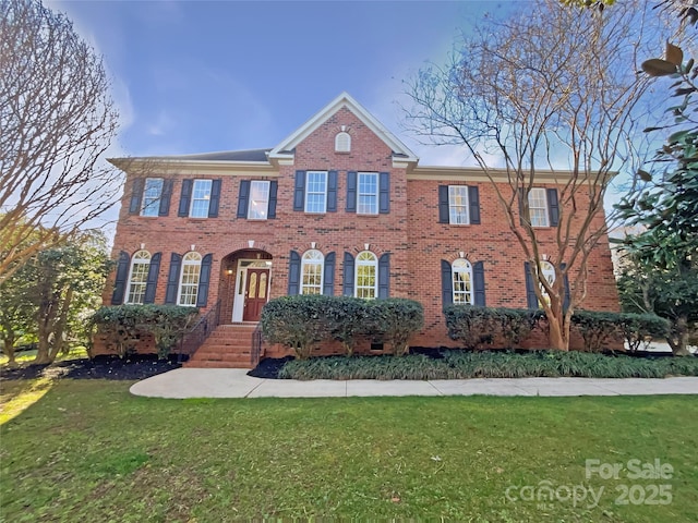 view of front of property with a front yard and brick siding