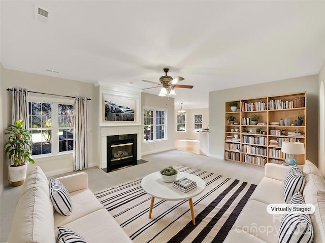 living room featuring visible vents, baseboards, a fireplace with flush hearth, carpet flooring, and a ceiling fan