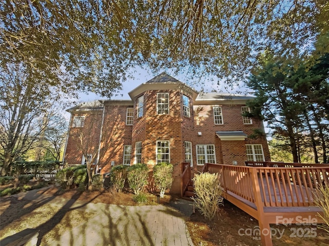 rear view of property with brick siding and a deck