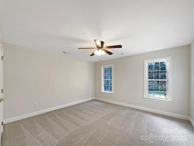 empty room featuring visible vents, a ceiling fan, baseboards, and carpet floors