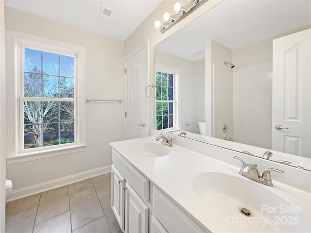 full bathroom featuring toilet, plenty of natural light, and a sink