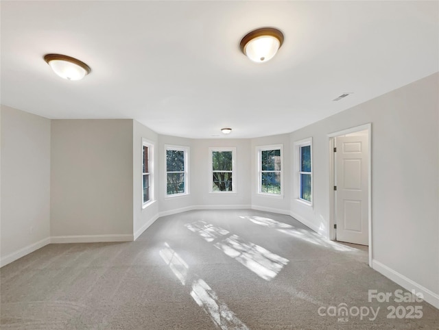 spare room with visible vents, baseboards, and carpet floors