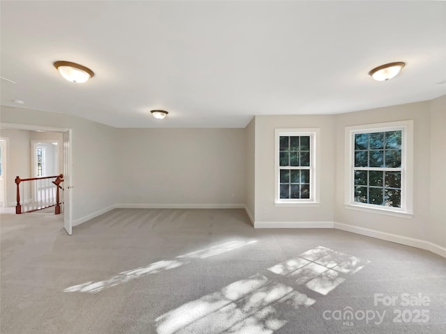 carpeted spare room featuring baseboards