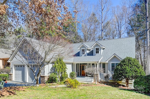 new england style home with a garage, a front lawn, and a shingled roof