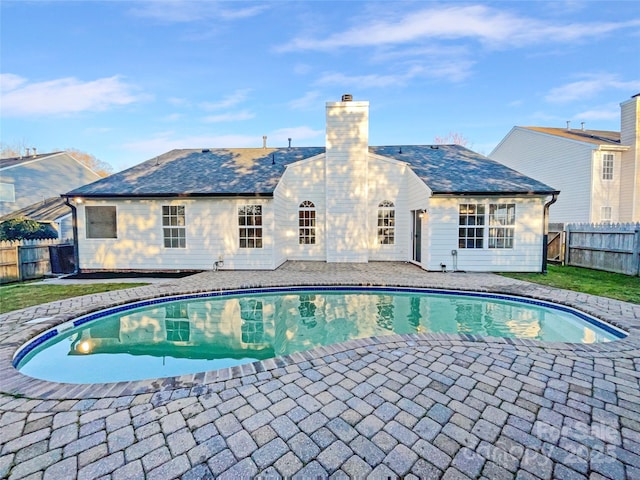 view of swimming pool featuring a fenced backyard, a fenced in pool, a lawn, and a patio