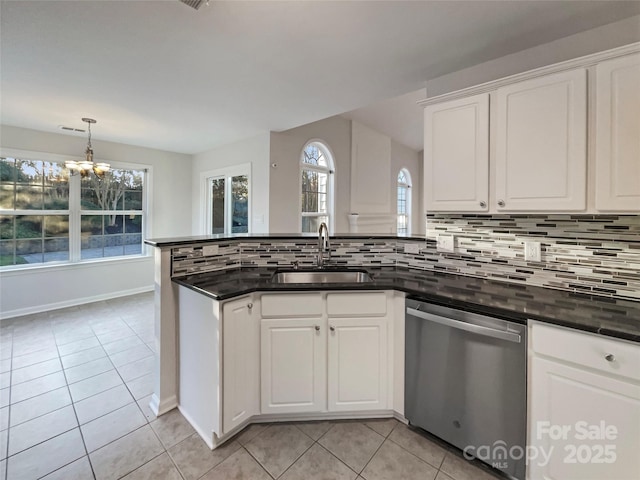 kitchen featuring a notable chandelier, a sink, stainless steel dishwasher, a peninsula, and light tile patterned flooring