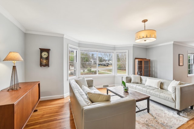 living room featuring visible vents, light wood-style flooring, baseboards, and ornamental molding