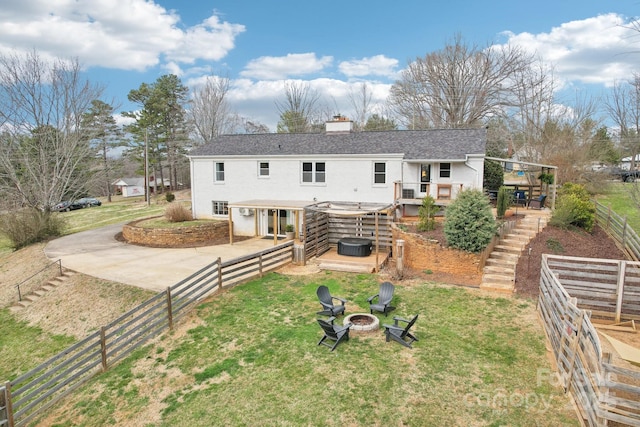 rear view of house featuring stairs, a lawn, a chimney, and an outdoor fire pit