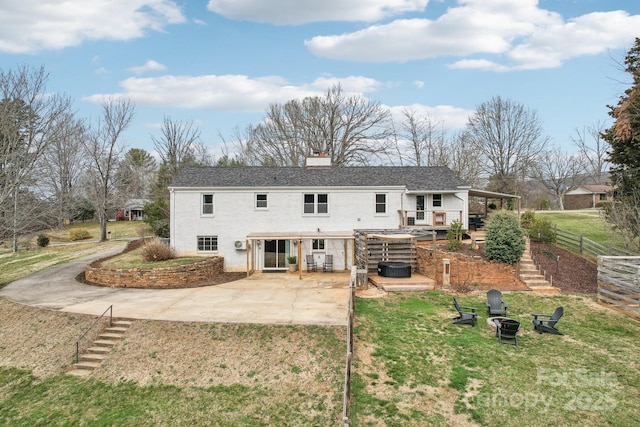 rear view of property with a patio area, stairway, an outdoor fire pit, and a yard