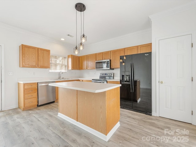 kitchen featuring a kitchen island, light wood-type flooring, appliances with stainless steel finishes, and a sink