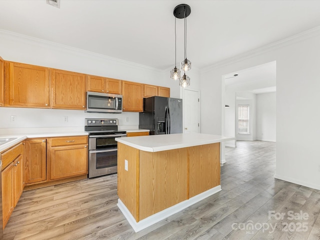 kitchen featuring crown molding, light wood finished floors, appliances with stainless steel finishes, and a center island