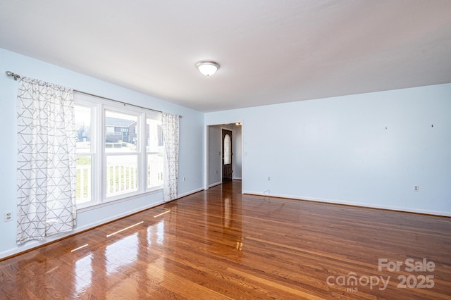 spare room with wood finished floors and baseboards