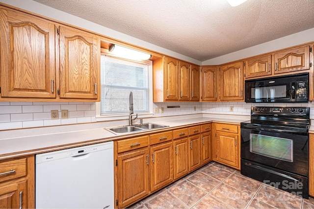 kitchen with brown cabinetry, a sink, black appliances, light countertops, and backsplash