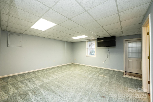 below grade area featuring a drop ceiling, baseboards, and carpet floors