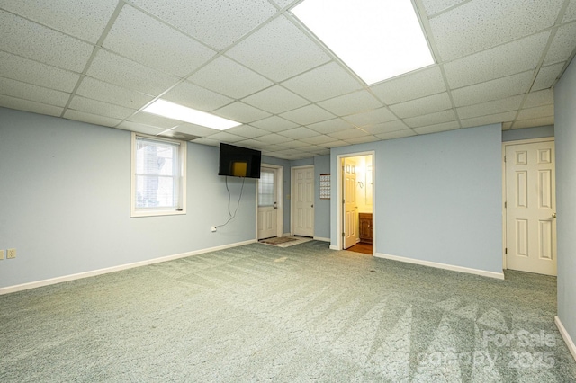 basement featuring baseboards, a paneled ceiling, and carpet