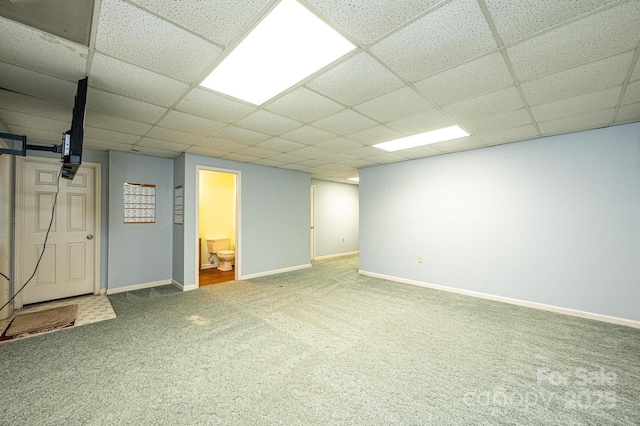 finished basement featuring a drop ceiling, baseboards, and carpet flooring