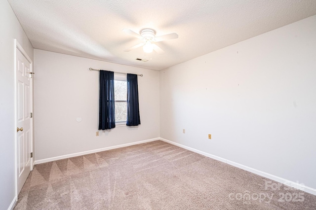 carpeted empty room featuring baseboards, a textured ceiling, and a ceiling fan