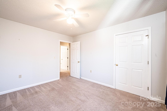 unfurnished bedroom with ceiling fan, a textured ceiling, baseboards, and carpet floors