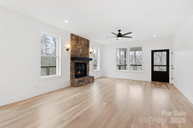 unfurnished living room featuring plenty of natural light, baseboards, and light wood finished floors