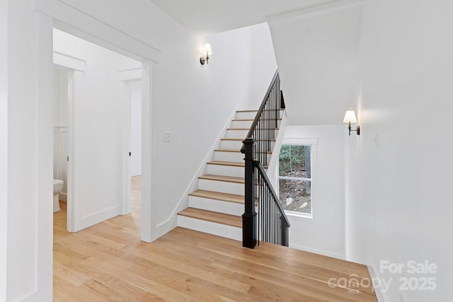 stairway featuring wood finished floors and baseboards