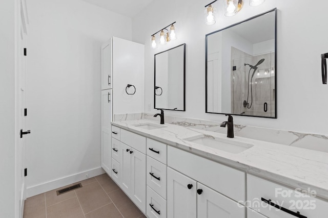 full bathroom featuring tile patterned flooring, a shower stall, visible vents, and a sink