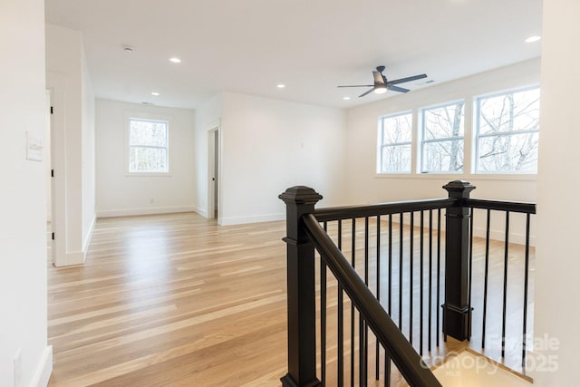 hall featuring recessed lighting, baseboards, an upstairs landing, and light wood-style floors