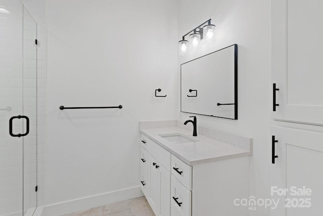 bathroom featuring a stall shower, vanity, and baseboards