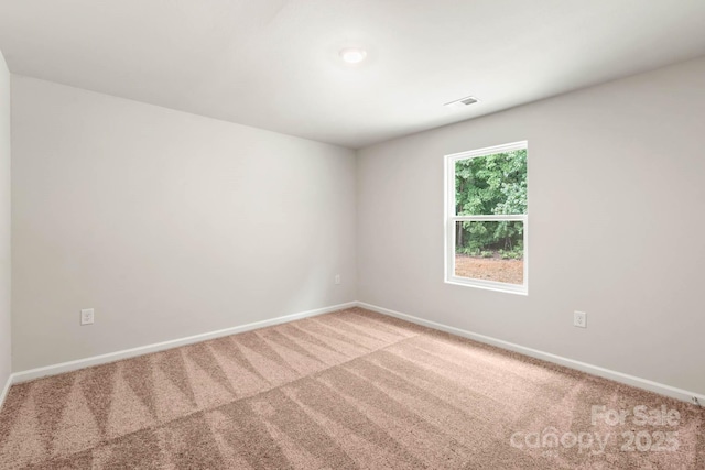 carpeted spare room featuring visible vents and baseboards