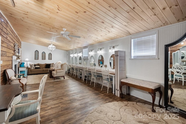 living room featuring a fireplace with raised hearth, wood ceiling, vaulted ceiling, wood finished floors, and a ceiling fan