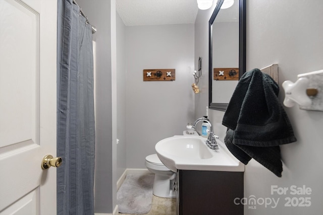 full bathroom with toilet, vanity, and baseboards