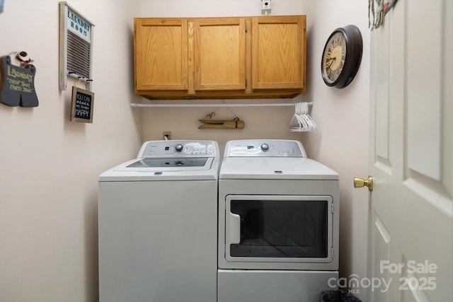 clothes washing area featuring washing machine and clothes dryer and cabinet space