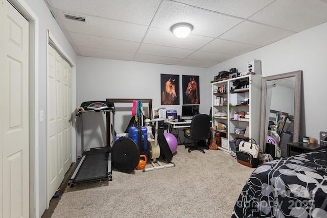 carpeted bedroom featuring a drop ceiling and visible vents