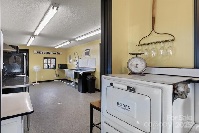 interior space with white cabinetry, washer / clothes dryer, speckled floor, and a textured ceiling