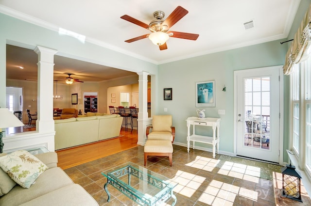 tiled living area featuring decorative columns, visible vents, ornamental molding, and a ceiling fan