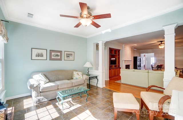 living room with visible vents, ceiling fan, ornamental molding, and ornate columns