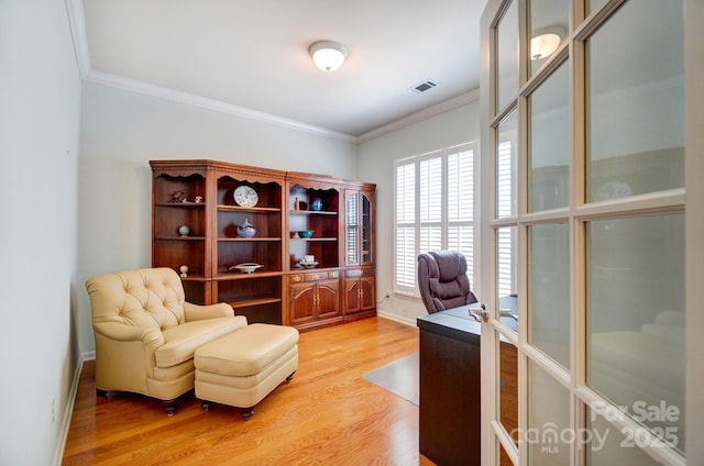 office with visible vents, baseboards, light wood-style flooring, and crown molding