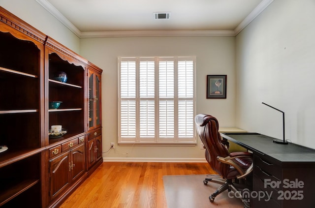 office space with crown molding, light wood-style floors, visible vents, and baseboards