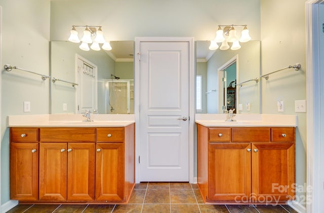 full bathroom with a notable chandelier, a stall shower, crown molding, and a sink