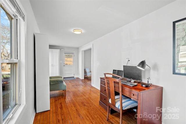 office space with baseboards and wood-type flooring