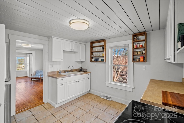 kitchen with a sink, open shelves, visible vents, and white cabinets