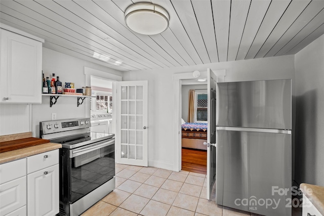 kitchen featuring light tile patterned flooring, stainless steel appliances, light countertops, white cabinets, and wood ceiling