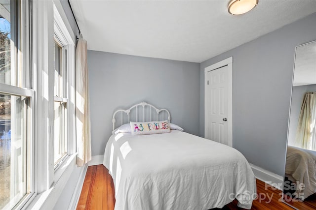 bedroom with wood finished floors and baseboards