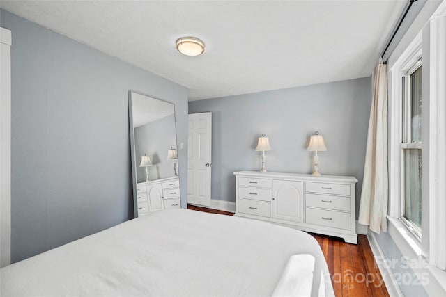 bedroom with baseboards and dark wood-style floors